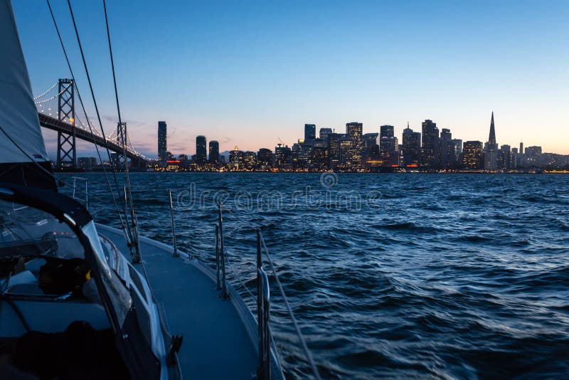 Sunset sail across San Francisco bay with city skyline still in view. Sunset sail across San Francisco bay with city skyline still in view