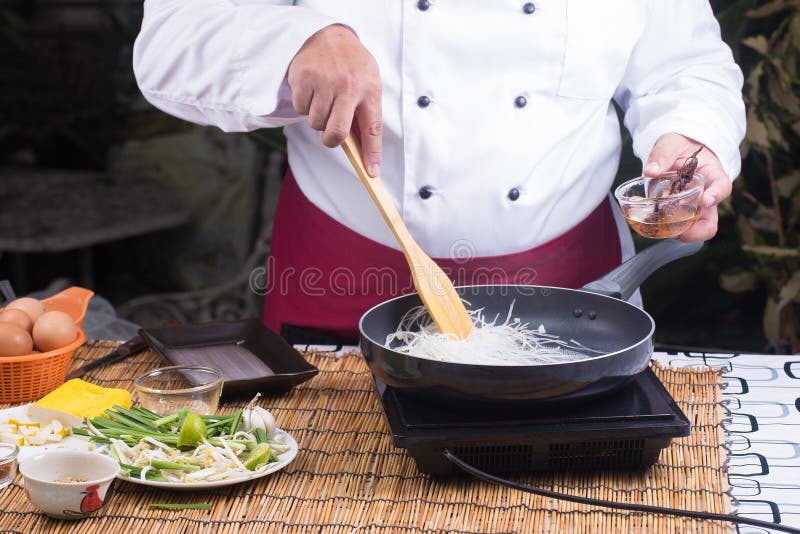 Noedel van de chef-kok stitr de gebraden rijst voor het koken van Stootkussen Thai stock foto Noedel van de chef-kok stitr de gebraden rijst voor het koken van Stootkussen Thai stock foto