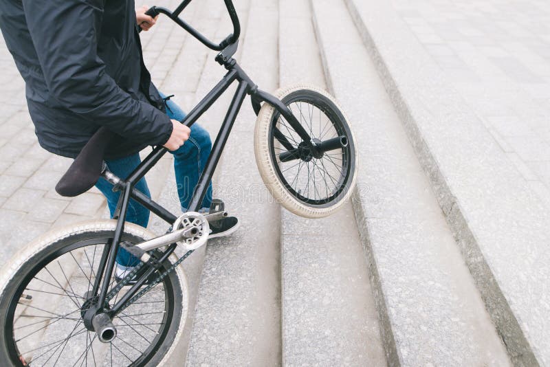Nogi BMX w górę i mężczyzna Cyklista podnosi BMX rower w górę schodków Miejsce dla teksta obraz stock Nogi BMX w górę i mężczyzna Cyklista podnosi BMX rower w górę schodków Miejsce dla teksta obraz stock