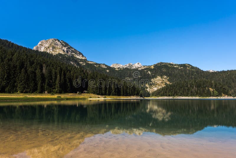 ` Noir de jezero de Crno de ` de lac avec des réflexions de crête de Meded dans l'eau clair comme de l'eau de roche, parc nationa photographie stock libre de droits ` Noir de jezero de Crno de ` de lac avec des réflexions de crête de Meded dans l'eau clair comme de l'eau de roche, parc nationa photographie stock libre de droits
