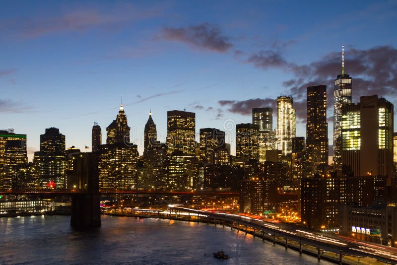 A noite de New York City ilumina a skyline no crepúsculo foto de stock A noite de New York City ilumina a skyline no crepúsculo foto de stock