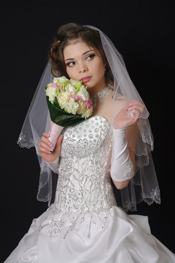 Beautiful bride with wedding bouquet on a dark background. Beautiful bride with wedding bouquet on a dark background