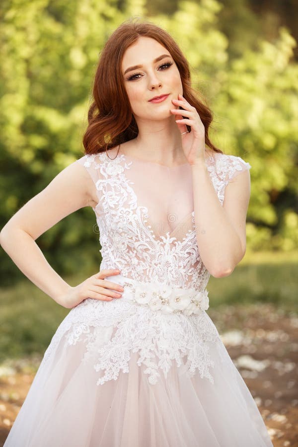 Noiva bonita do ruivo no vestido de casamento fantástico no jardim de florescência fotos de stock Noiva bonita do ruivo no vestido de casamento fantástico no jardim de florescência fotos de stock