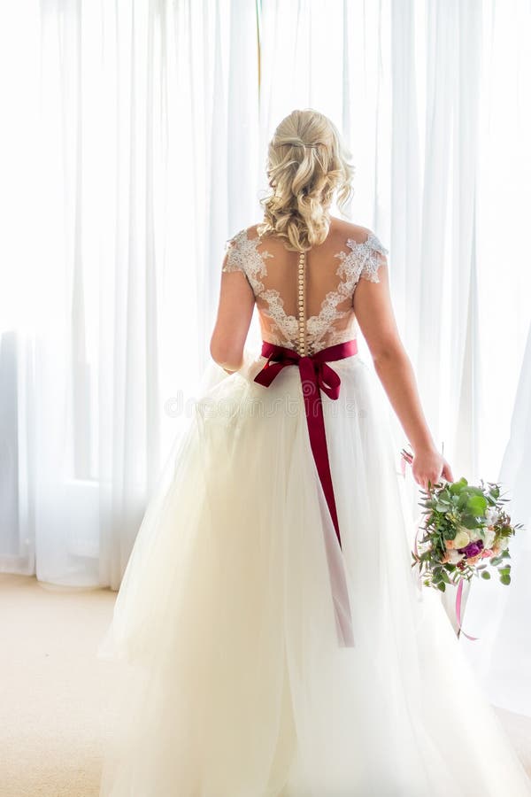 Noiva bonita em um vestido branco com um ramalhete das flores isoladas no fundo branco fotos de stock Noiva bonita em um vestido branco com um ramalhete das flores isoladas no fundo branco fotos de stock