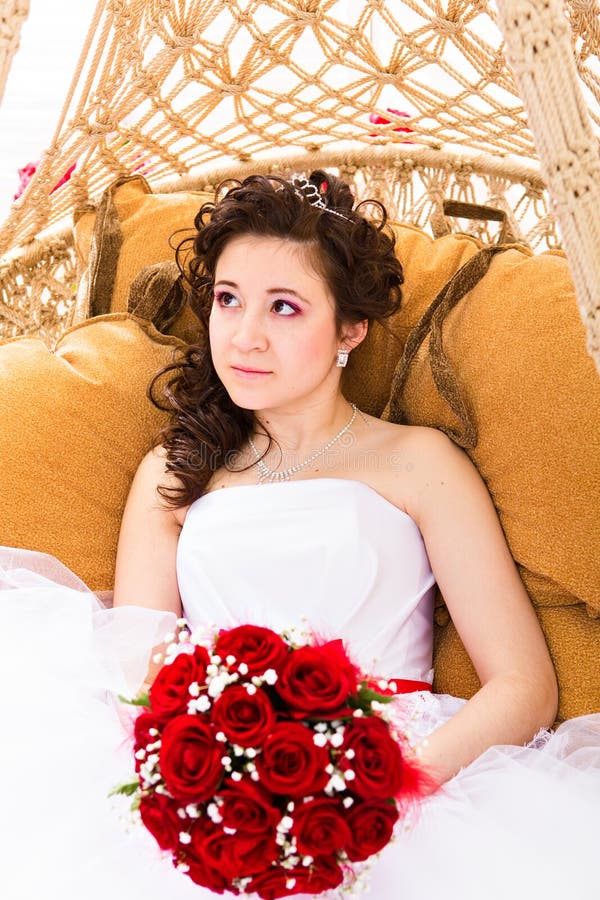 Noiva bonita no vestido branco que guarda rosas vermelhas do ramalhete do casamento imagens de stock Noiva bonita no vestido branco que guarda rosas vermelhas do ramalhete do casamento imagens de stock