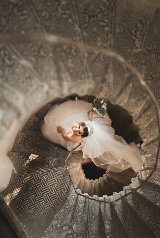 A noiva bonita no vestido magnífico está apenas em escadas fotos de stock A noiva bonita no vestido magnífico está apenas em escadas fotos de stock