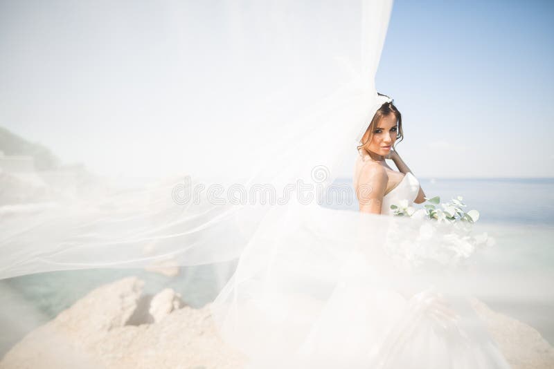 Noiva bonita romântica no vestido branco que levanta no mar do fundo imagens de stock royalty free Noiva bonita romântica no vestido branco que levanta no mar do fundo imagens de stock royalty free