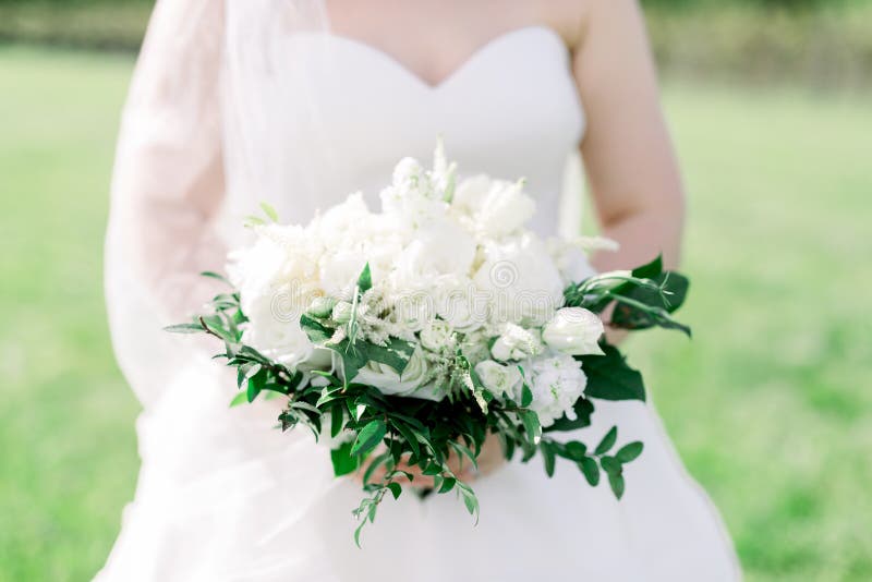 Noiva De Vestido Branco Segurando Um Bouquet Branco De Rosas Com Verde  Imagem de Stock - Imagem de noiva, acentos: 170857785