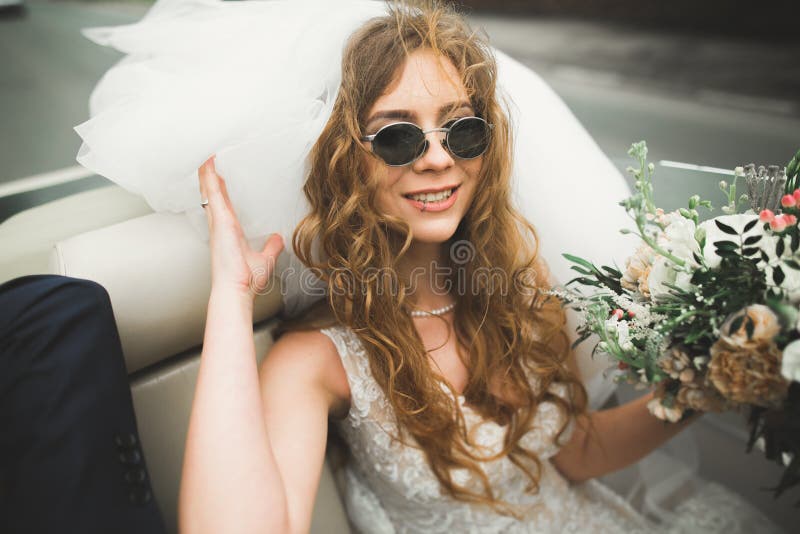 Noiva feliz no carro retro que levanta em seu dia da remoção de ervas daninhas imagem de stock royalty free Noiva feliz no carro retro que levanta em seu dia da remoção de ervas daninhas imagem de stock royalty free
