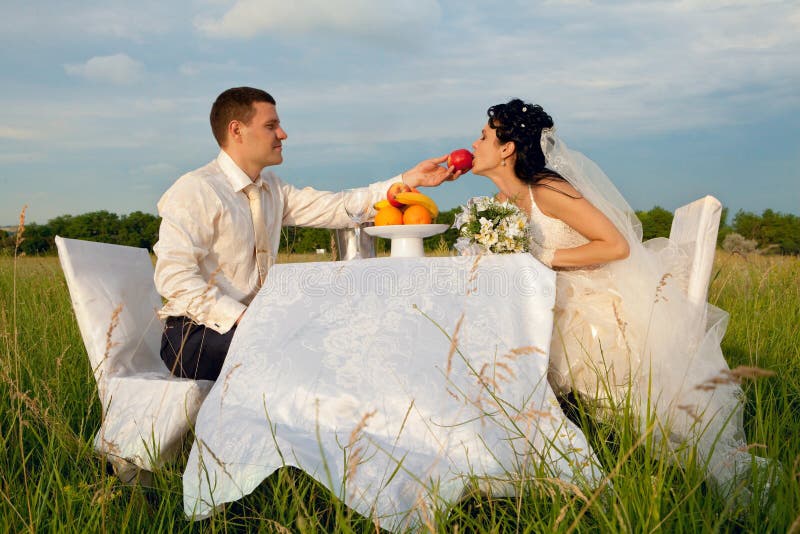 Noivo a oferecer uma maçã à noiva foto de stock royalty free