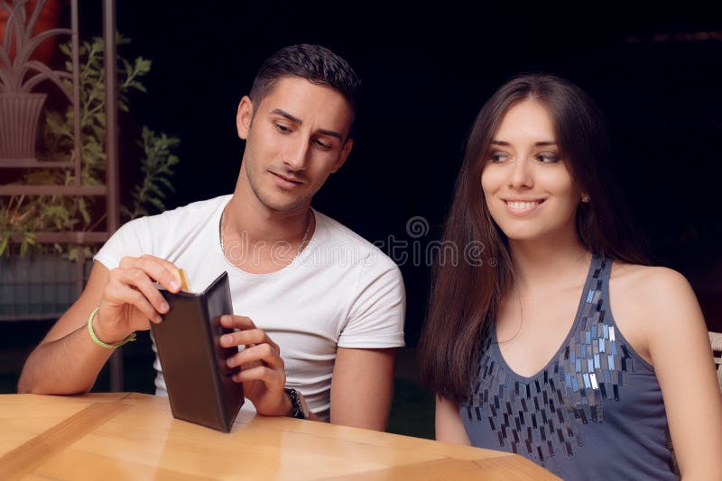 Noivo que verifica o restaurante Bill em uma data imagens de stock royalty free Noivo que verifica o restaurante Bill em uma data imagens de stock royalty free