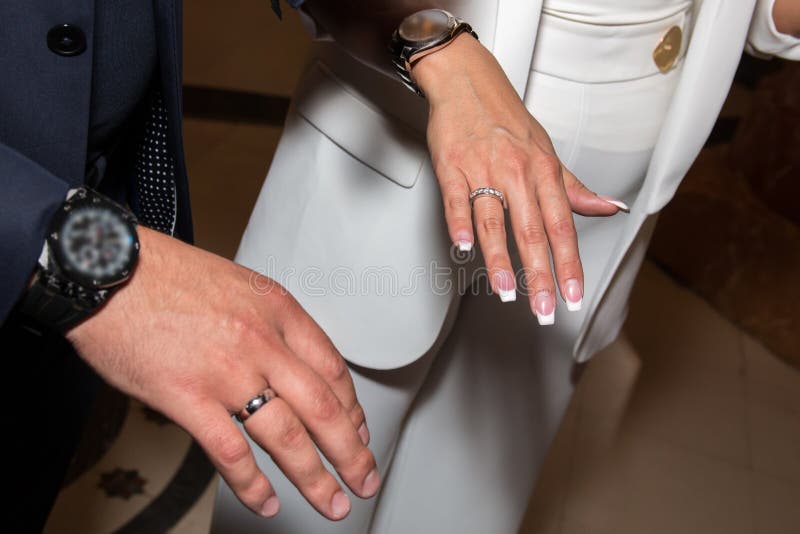 Noivos que mostram as alianças de casamento em seus dedos Mãos masculinas e fêmeas com anéis de casamento imagem de stock Noivos que mostram as alianças de casamento em seus dedos Mãos masculinas e fêmeas com anéis de casamento imagem de stock
