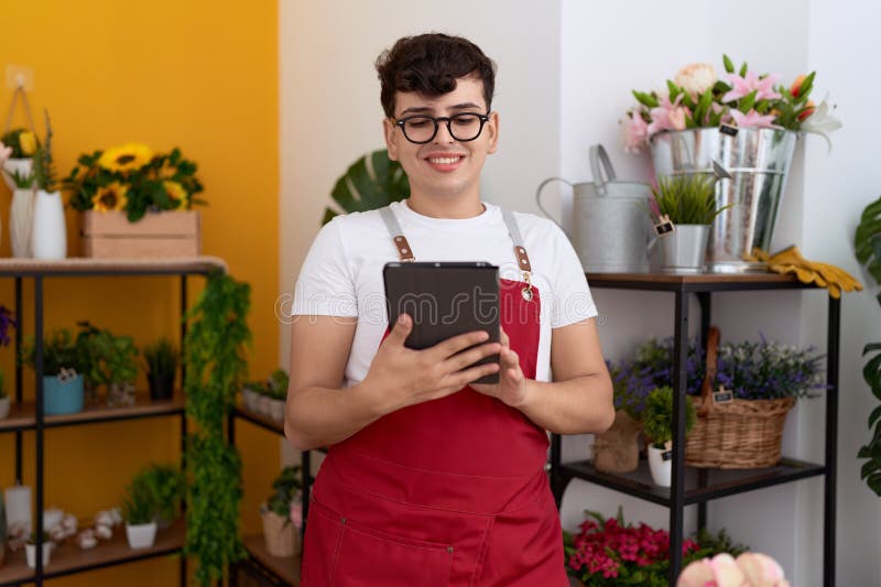 Non Binary Man Florist Smiling Confident Using Touchpad at Flower Shop
