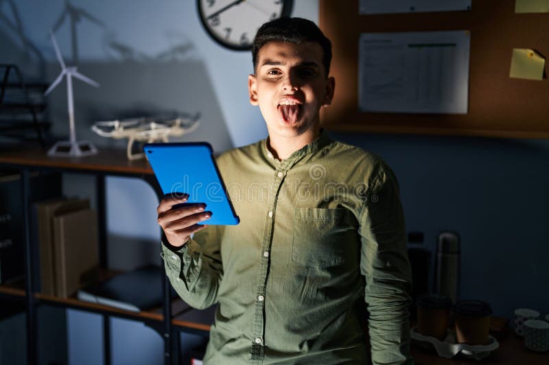 Non Binary Person Using Touchpad Device at Night Sticking Tongue Out Happy with Funny Expression