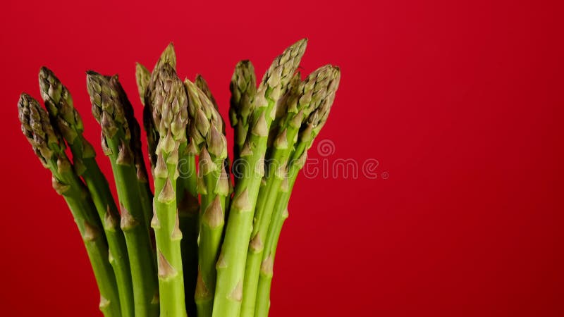 πράσινα σπαράγγια σε κόκκινο φόντο απόθεμα βίντεο