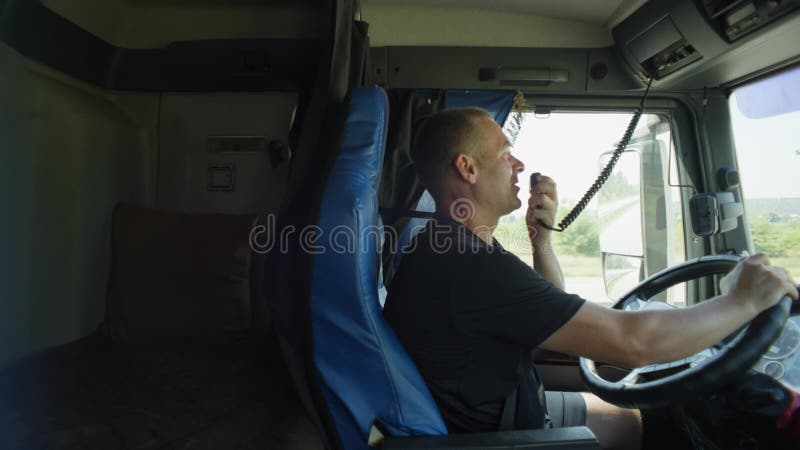 ένας οδηγός μεγάλων αποστάσεων παίρνει ένα γουόκι-τόκι στα χέρια του. φιλμ μικρού μήκους
