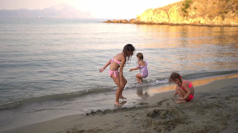Τρία μικρά κορίτσια παίζουν στην παραλία σαρτί ελλάδα απόθεμα βίντεο