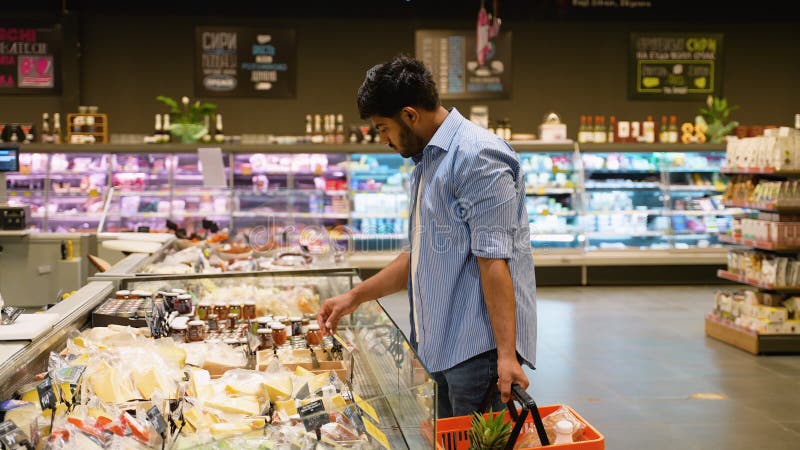 Ένας Ινδός άνδρας επιλέγει και αγοράζει τυρί στο σούπερ μάρκετ απόθεμα βίντεο