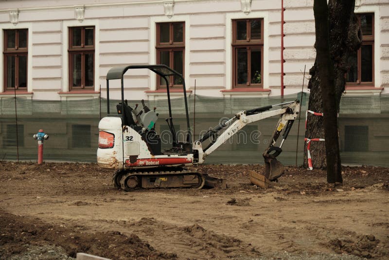 Мини-экскаватор на городской строительной и ландшафтной площадке в Орадее стоковое фото rf