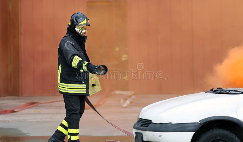 Пожарные во время тренировки для того чтобы потушить огонь в автомобиле стоковая фотография