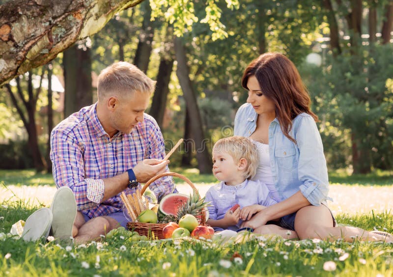 Ευτυχής οικογένεια σε ένα πικ-νίκ σε ένα πάρκο στοκ φωτογραφία με δικαίωμα ελεύθερης χρήσης