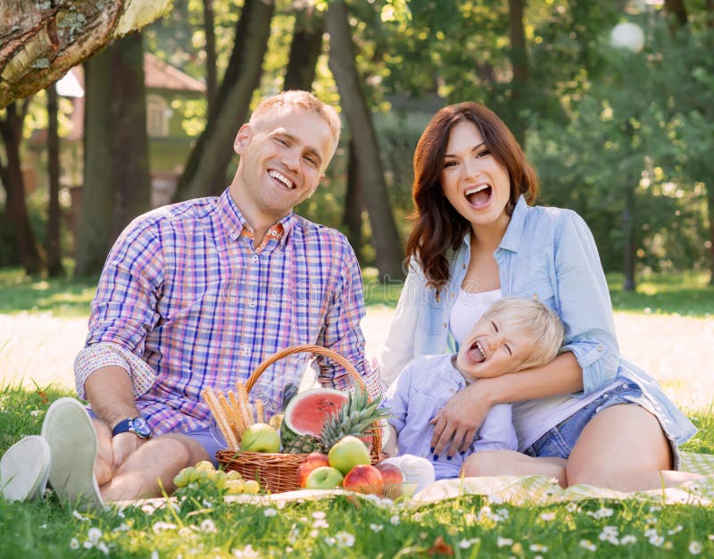 Ευτυχισμένη οικογένεια σε πικνίκ σε ένα πάρκο στοκ εικόνα με δικαίωμα ελεύθερης χρήσης