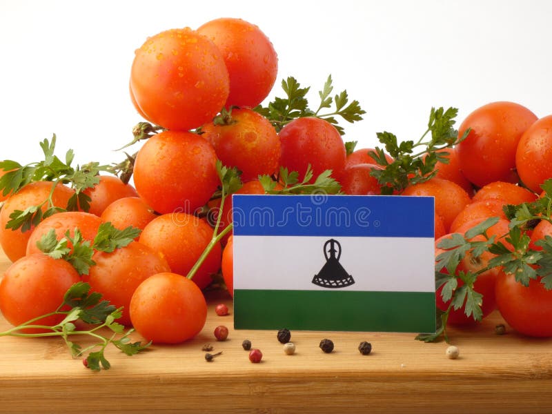 Флаг Лесото на деревянной панели при томаты изолированные на белизне стоковые фотографии rf