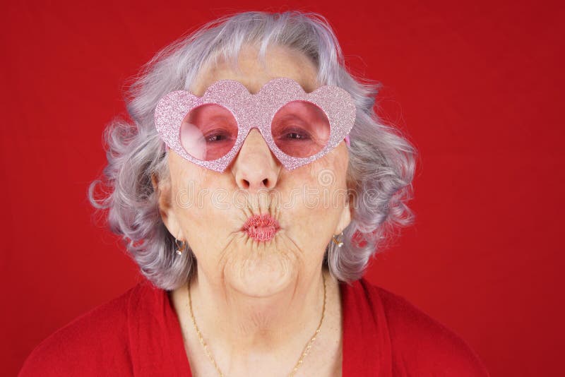 Comical granny with heart shape glasses blowing kiss. Comical granny with heart shape glasses blowing kiss