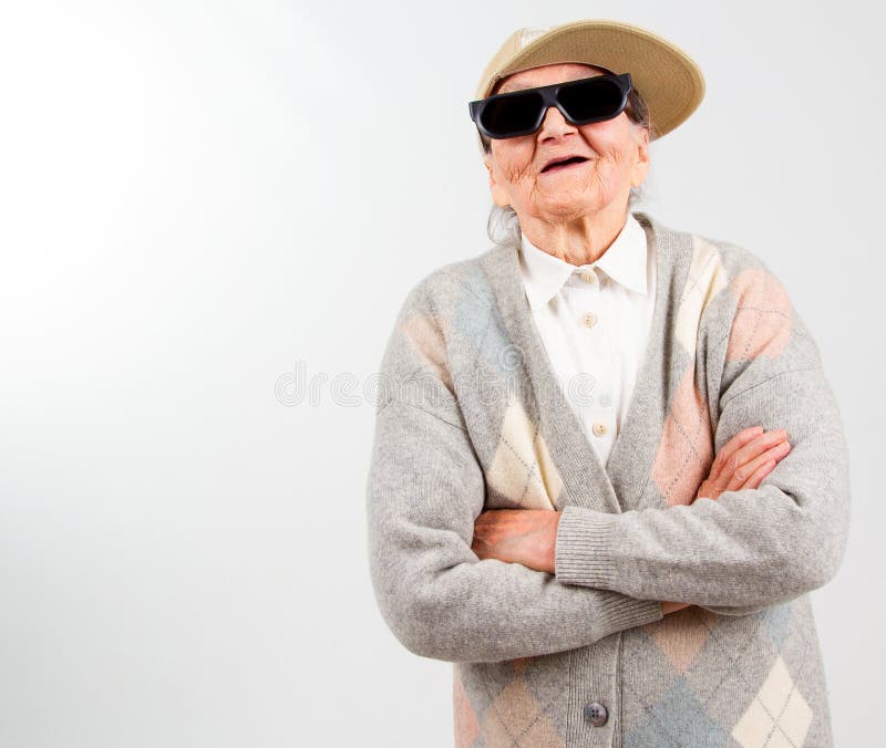 Funny grandma's studio portrait wearing eyeglasses and baseball cap, isolated on white. Funny grandma's studio portrait wearing eyeglasses and baseball cap, isolated on white