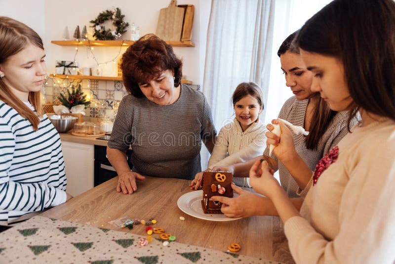 Nonna sorridente con figlia e nipoti che cucinano insieme biscotti natalizi in cucina. donna matura con la sua bella felicità fotografie stock libere da diritti