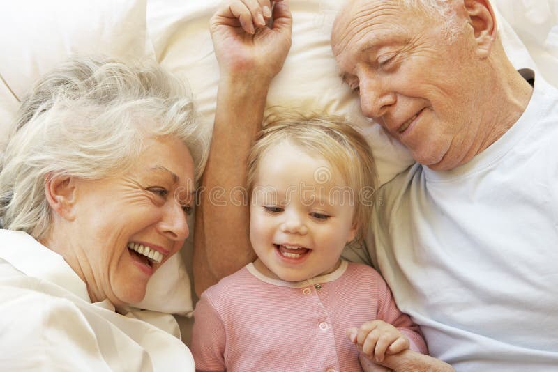 Nonni che stringono a sé nipote a letto Nonni che stringono a sé nipote a letto