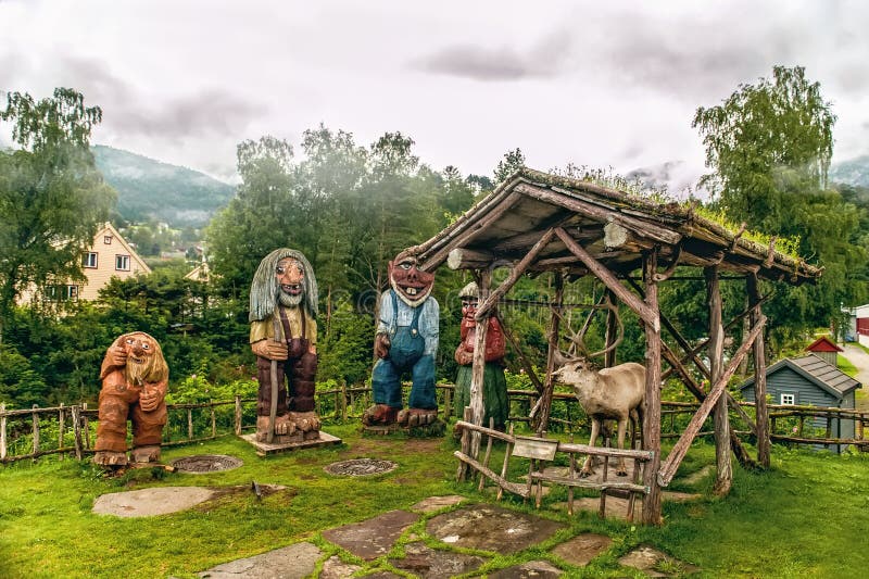 Noorse gesneden houten beeldhouwwerken van sleeplijnen en een rendier op een achtergrond van bergen in de nevelige ochtend Skandi stock afbeelding Noorse gesneden houten beeldhouwwerken van sleeplijnen en een rendier op een achtergrond van bergen in de nevelige ochtend Skandi stock afbeelding