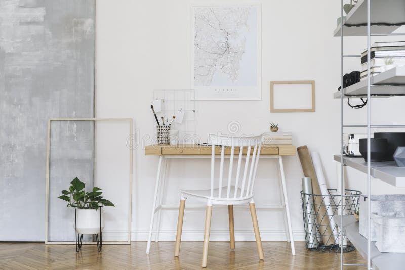 Nordic home interior with wooden desk, chair, design sofa, coffee table, bookstand and art accessories. Open artistic space.