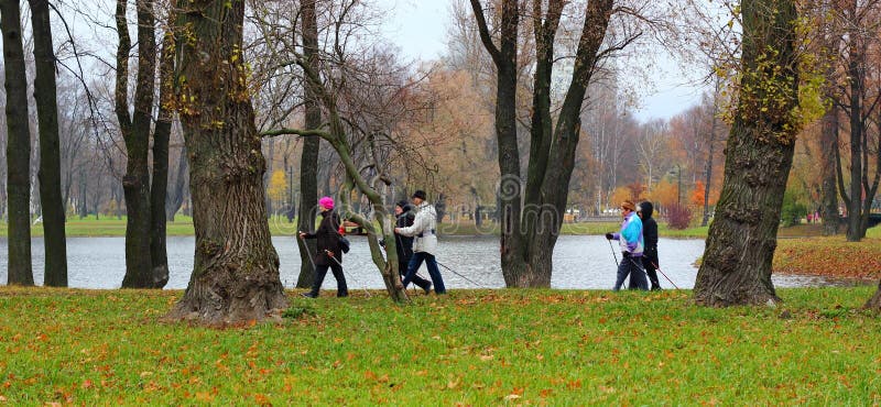 Nordic que camina en parque en otoño fotos de archivo