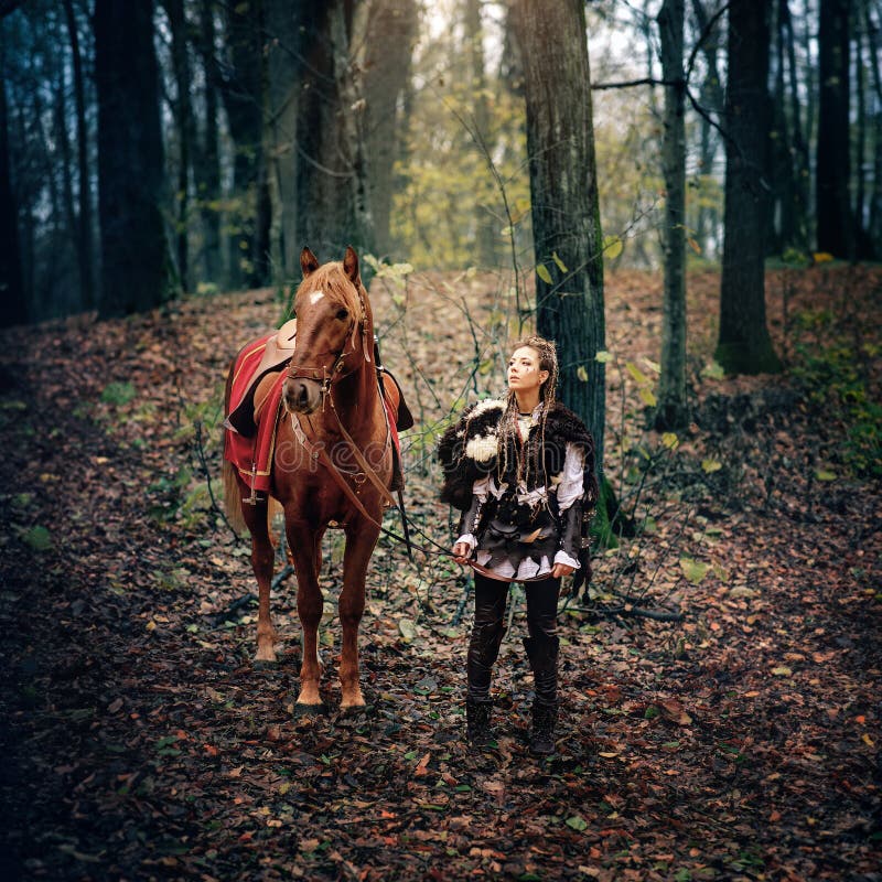 Nordic Viking Warrior Woman and Her Majestic Horse Embrace the Forest in Medieval Scene Reconstruction, royalty free stock images Nordic Viking Warrior Woman and Her Majestic Horse Embrace the Forest in Medieval Scene Reconstruction, royalty free stock images