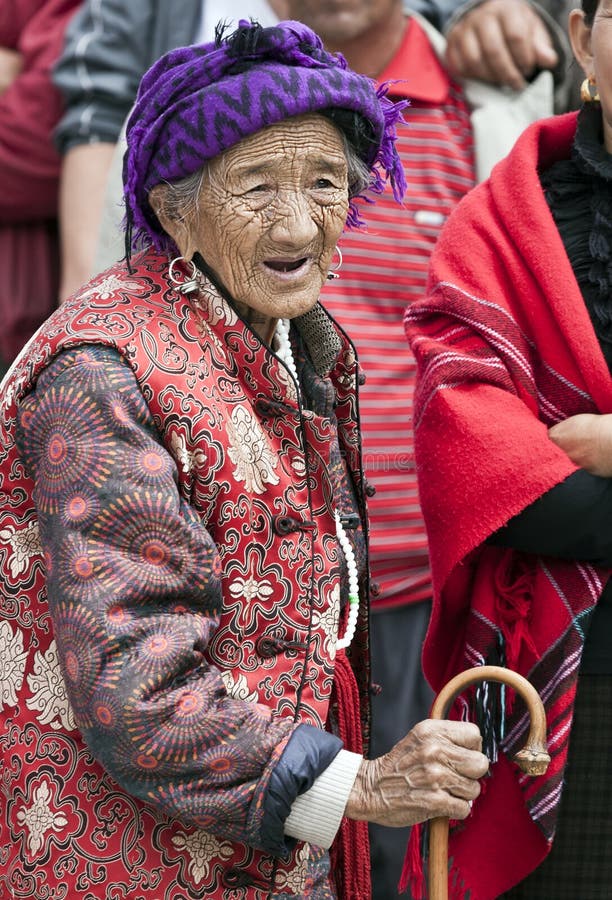 An old woman walks through the crowded streets of Zhongdian during a festival in northern Yunnan province in China. An old woman walks through the crowded streets of Zhongdian during a festival in northern Yunnan province in China.