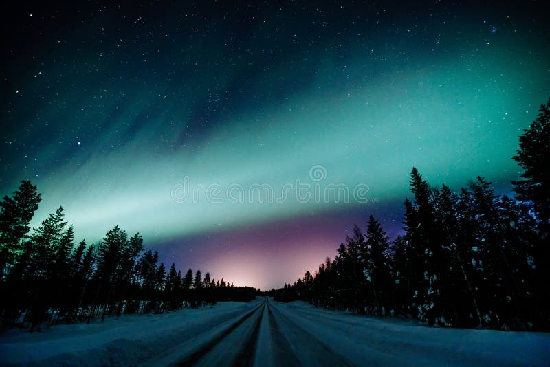 Northern lights Aurora Borealis activity over the road in winter Finland