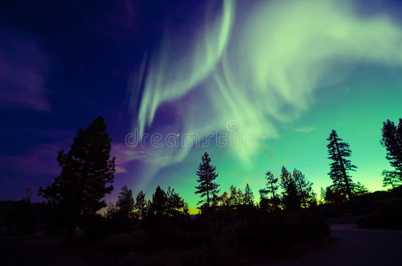 Northern lights aurora borealis in the night sky over beautiful lake landscape