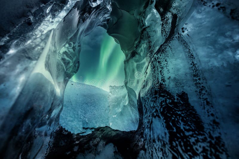 Northern Lights Aurora Borealis Over Glacier Ice Cave. Stock Photo