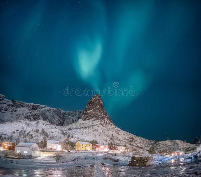 Northern lights on snow mountain with fishing village at Lofoten islands stock image Northern lights on snow mountain with fishing village at Lofoten islands stock image