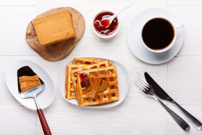 Norwegian brunost on white table. Breakfast with Scandinavian brown cheese, homemade waffles and coffee. Top view royalty free stock photo Norwegian brunost on white table. Breakfast with Scandinavian brown cheese, homemade waffles and coffee. Top view royalty free stock photo