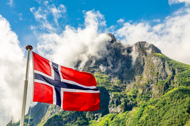 Norwegische Staatsflagge, die in den Wind und in das mountain& x27 wellenartig bewegt; s-Spitze in Neroy-Fjord, Aurlan, Sogn-og F lizenzfreie stockfotos Norwegische Staatsflagge, die in den Wind und in das mountain& x27 wellenartig bewegt; s-Spitze in Neroy-Fjord, Aurlan, Sogn-og F lizenzfreie stockfotos