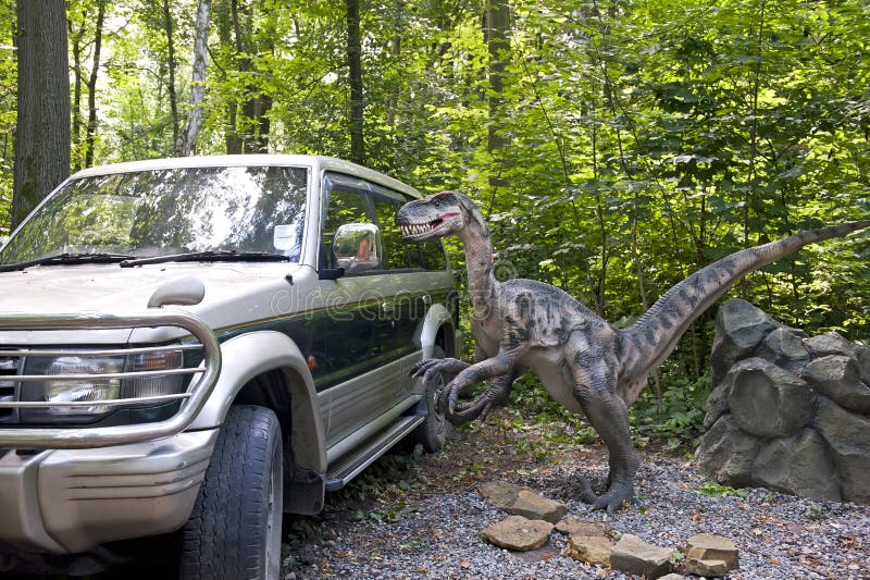 View of the nosey dinosaur near the off-road car in the forest.