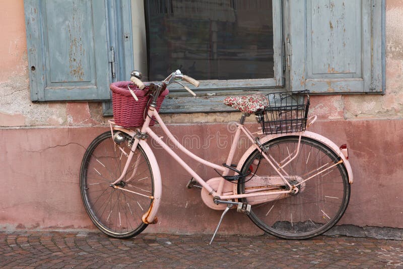 Nostalgic pink bike against house facade. Aged nostalgic pink bicycle, leaning against house wall and window stock images Nostalgic pink bike against house facade. Aged nostalgic pink bicycle, leaning against house wall and window stock images