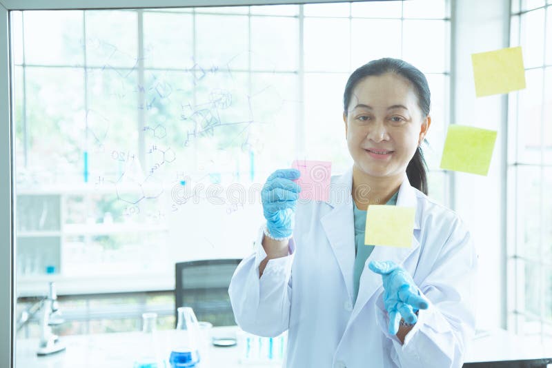 Nota di scarsità variopinta della donna del bastone asiatico dello scienziato sul bordo immagini stock Nota di scarsità variopinta della donna del bastone asiatico dello scienziato sul bordo immagini stock