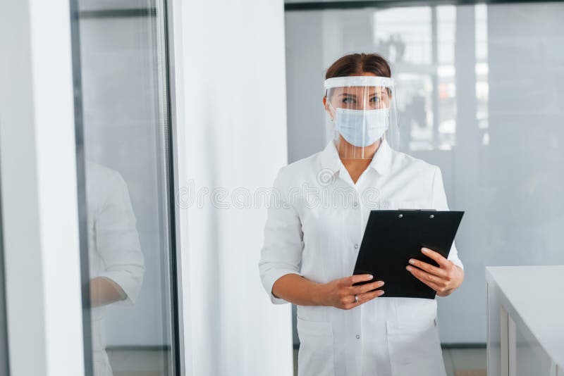 Nota en las manos. médico profesional con abrigo blanco está en la clínica foto de archivo