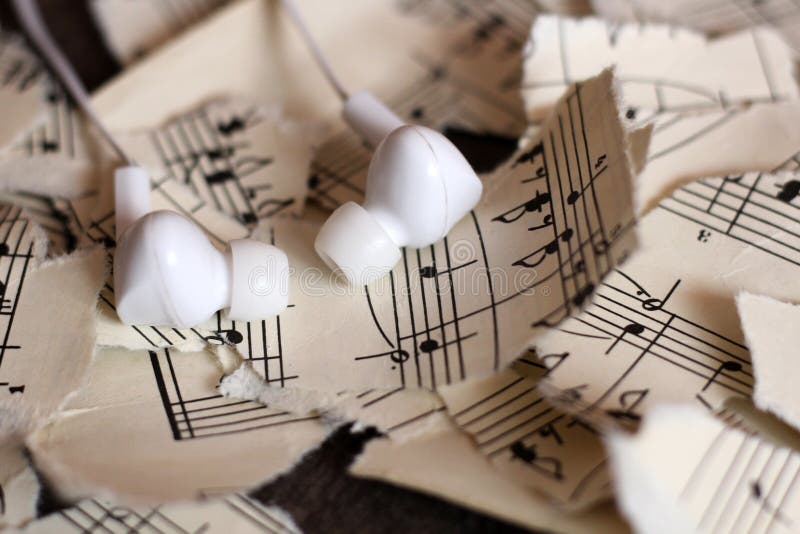 Notas musicais rasgadas, pedaços de papel, fones de ouvido brancos do vácuo foto de stock royalty free Notas musicais rasgadas, pedaços de papel, fones de ouvido brancos do vácuo foto de stock royalty free