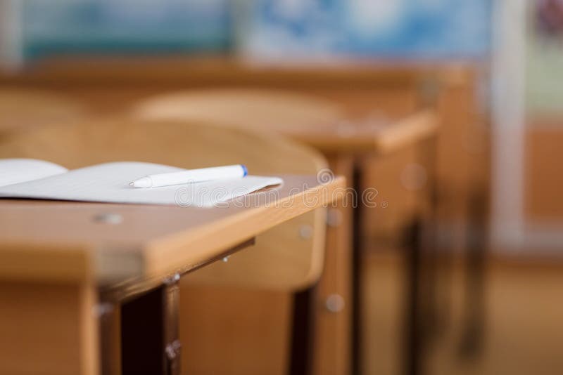 Notatnik i pióro jesteśmy na stole Szkolna sala lekcyjna w plamy tle bez młodego ucznia fotografia royalty free Notatnik i pióro jesteśmy na stole Szkolna sala lekcyjna w plamy tle bez młodego ucznia fotografia royalty free