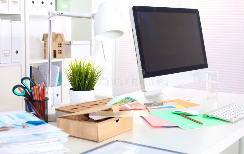 A note book, laptop, pen, graph paper document on the office desk table behind white blind