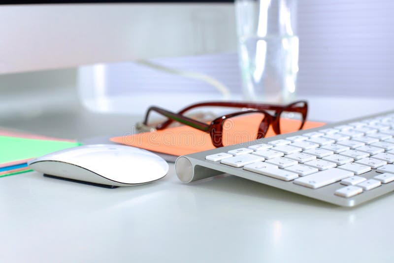 A note book, laptop, pen, graph paper document on the office desk table behind white blind